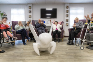 Customers of ECL sit in a armchairs in the lounge admiring the mini bee sculpture that they will decorate