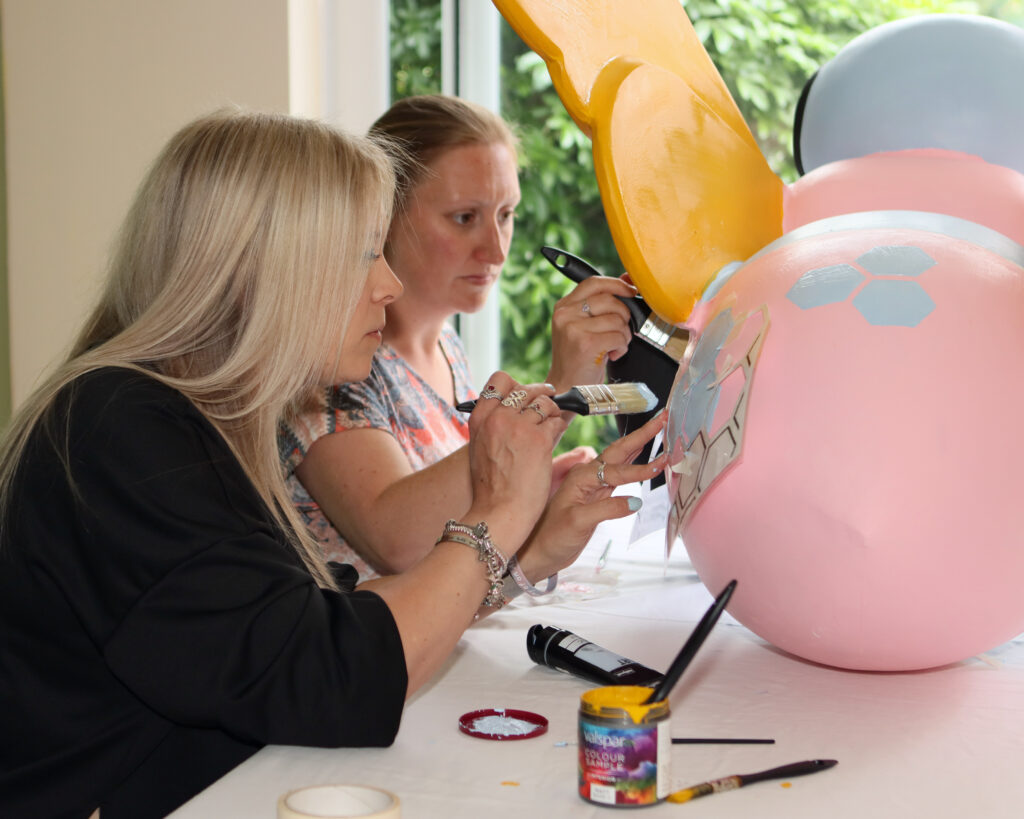 Two members of the group, Amy and Louise, decorate the mini bee