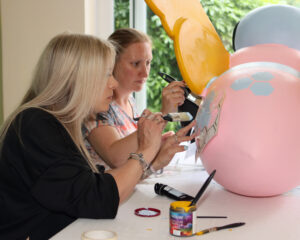 Two members of the group, Amy and Louise, decorate the mini bee